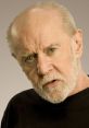 George Carlin with a serious expression, showcasing his signature wit and bold humor in a classic black shirt.