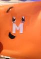 Orange background featuring a playful character with a large "M" and expressive eyes, capturing fun and creativity.