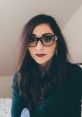 Valentina Fussell from House of Valentina, showcasing a chic look with glasses and stylish layered clothing.