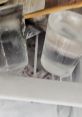 Two clear glass cups filled with ice and water, resting in a cluttered freezer, showcasing everyday refreshment.