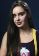 Portrait of Loserfruit with long hair, wearing a colorful top and playful earrings, showcasing her engaging personality.