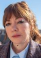 Philomena Cunk poses outdoors, showcasing her signature style and expression in a vibrant, sunlit setting.