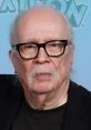 Legendary filmmaker John Carpenter with glasses and distinctive mustache, known for iconic horror and sci-fi movies.