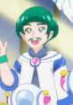 Toto from Star Twinkle Pretty Cure smiles cheerfully, wearing a colorful outfit and showcasing his signature green hairstyle.