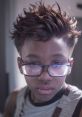 Boy with spiky hair and glasses, showcasing a unique style. Emphasizes creative expression in fashion and personality.