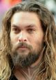 Close-up of Jason Momoa showcasing his intense gaze and signature long hair, known for his powerful voice and charismatic presence.