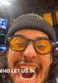 Excited fan with sunglasses and beanie shouting at a basketball game, embodying the spirit of Jamie Reyes.