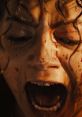 Isabela Merced expressing intense anger, blood on her face, capturing a powerful emotional moment in a dramatic scene.