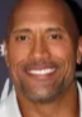 Dwayne "The Rock" Johnson smiles confidently at a red carpet event, showcasing his charismatic WWE persona and charm.