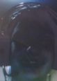 Close-up of a person wearing headphones, focused on gaming or streaming, with a blurred background and low lighting.