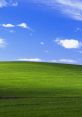 Lush green hill under a bright blue sky with fluffy clouds, symbolizing tranquility and natural beauty in a vibrant landscape.