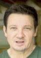 Jeremy Renner speaking directly to the camera, showcasing his signature intense expression in a casual setting.