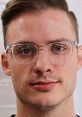 Young man with glasses, focused expression, promoting Mralextech's innovative tech solutions and services.