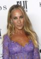 Sarah Jessica Parker in a stunning purple lace dress, showcasing her glamorous style at a red carpet event.
