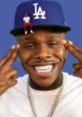 DaBaby sports a blue LA cap, flashing a big smile while posing playfully for the "DABABY HA" vibe.