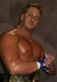 Danny Doring showcasing muscular physique and championship belts, embodying the spirit of professional wrestling.