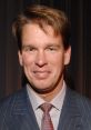 JBL, former WWE champion, smiling in a formal suit at an event, showcasing his signature style and charisma.