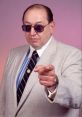 Gorilla Monsoon in a stylish suit and sunglasses, pointing assertively for an impactful photo. Classic wrestling persona.