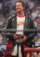 Roddy Piper in a leather jacket and kilt, showcasing his iconic style during a wrestling event.