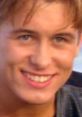 Smiling young man with bright blue eyes and styled hair, capturing a moment of happiness and charisma, possibly Mark Owen.