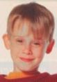 Young boy with a cheerful expression, reminiscent of Kevin McCallister from the classic holiday film "Home Alone.