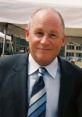 Paul Steigerwald smiling in a professional suit, showcasing his approachable demeanor at a public event.