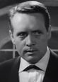 Patrick McGoohan in a classic black and white scene, exuding intense emotion and mystery in sophisticated attire.