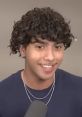 Young man with curly hair and a friendly smile, speaking into a microphone, highlighting topics related to cash.