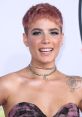 Halsey smiles confidently, showcasing a trendy short hairstyle and stylish accessories at a glamorous event.