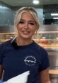 Smiling woman in a Merchants Fish & Chips shirt, highlighting the vibrant atmosphere of a seafood restaurant.