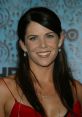 Lauren Graham smiles radiantly in a red dress at a glamorous event, showcasing her elegant style and charm.