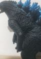Detailed figure of a talking Godzilla, showcasing intricate scales and vibrant blue spines against a neutral background.
