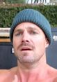 Stephen Amell with a surprised expression, wearing a blue beanie, showcasing his striking blue eyes in a casual setting.