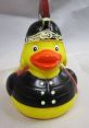 Duck wearing a black soldier's uniform and hat, featuring a bright yellow body and cheerful expression. Perfect for collectors!