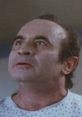 Distressed man in hospital gown, expressing shock in a classic American movie about heart conditions and personal struggles.