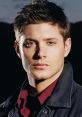 Close-up of Dean Winchester from Supernatural, showcasing his intense gaze and rugged style against a dark backdrop.
