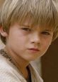 Young Anakin Skywalker gazes intently, showcasing innocence and potential in a key moment from Star Wars Episode I.