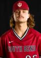 South Bend baseball player in red jersey and cap, representing IUSB with pride and confidence.