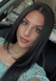 Selfie of a woman with long black hair and a floral top, showcasing her unique style and natural beauty.