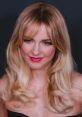 Mckenna Grace showcases glamorous wavy hair and vibrant makeup, exemplifying her youthful charm and star power.