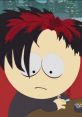 Goth kid with striking black and red hair looks pensive while sitting at a table with cigarette and ashtray.