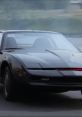 Classic KITT racing down the road, showcasing its iconic sleek black design and distinctive red scanner lights.