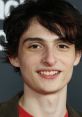 Finn Wolfhard smiling at an event, showcasing his youthful charm and talent in acting, resonating with fans and viewers.