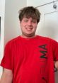 Smiling young man wearing a red Puma shirt, showcasing a casual style with a friendly demeanor.