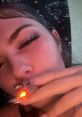 Close-up of a person with striking eyelashes holding a glowing object, showcasing a trendy, relaxed vibe.