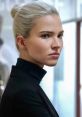 Focused portrait of a woman with sleek blonde hair and a serious expression, showcasing a powerful presence.
