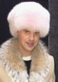 Nick Colletti sporting a stylish fur coat and a fluffy pink hat, showcasing a unique fashion statement.