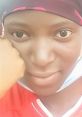 Close-up of a young woman in a red shirt and headscarf, showcasing a thoughtful expression and natural beauty.