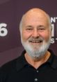 Rob Reiner smiling in a black shirt, showcasing his approachable personality at a public event.