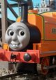 Cheerful Billy from TTTE poses on the tracks, showcasing his vibrant orange design and friendly expression.